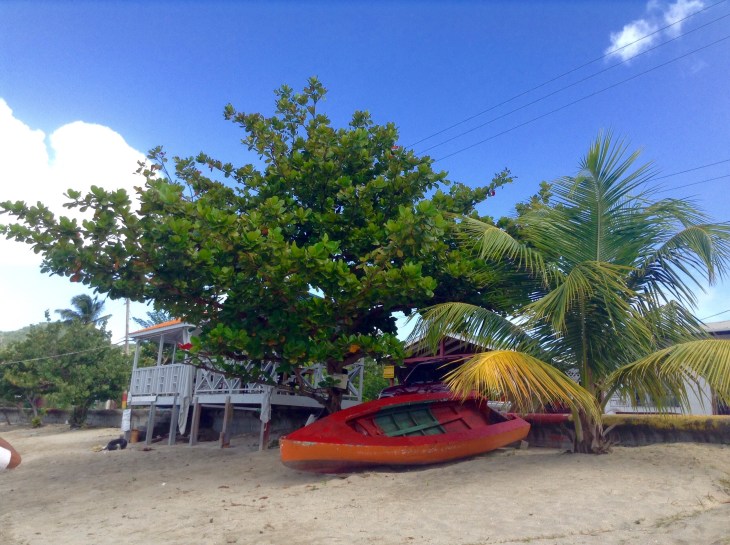 White wood house on the beach, red kayak, Tyrrel Carricou 